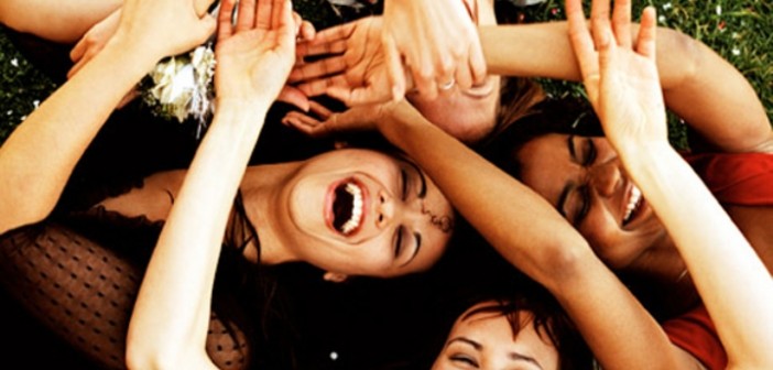 Elevated view of a group of young women lying on a lawn with their hands together